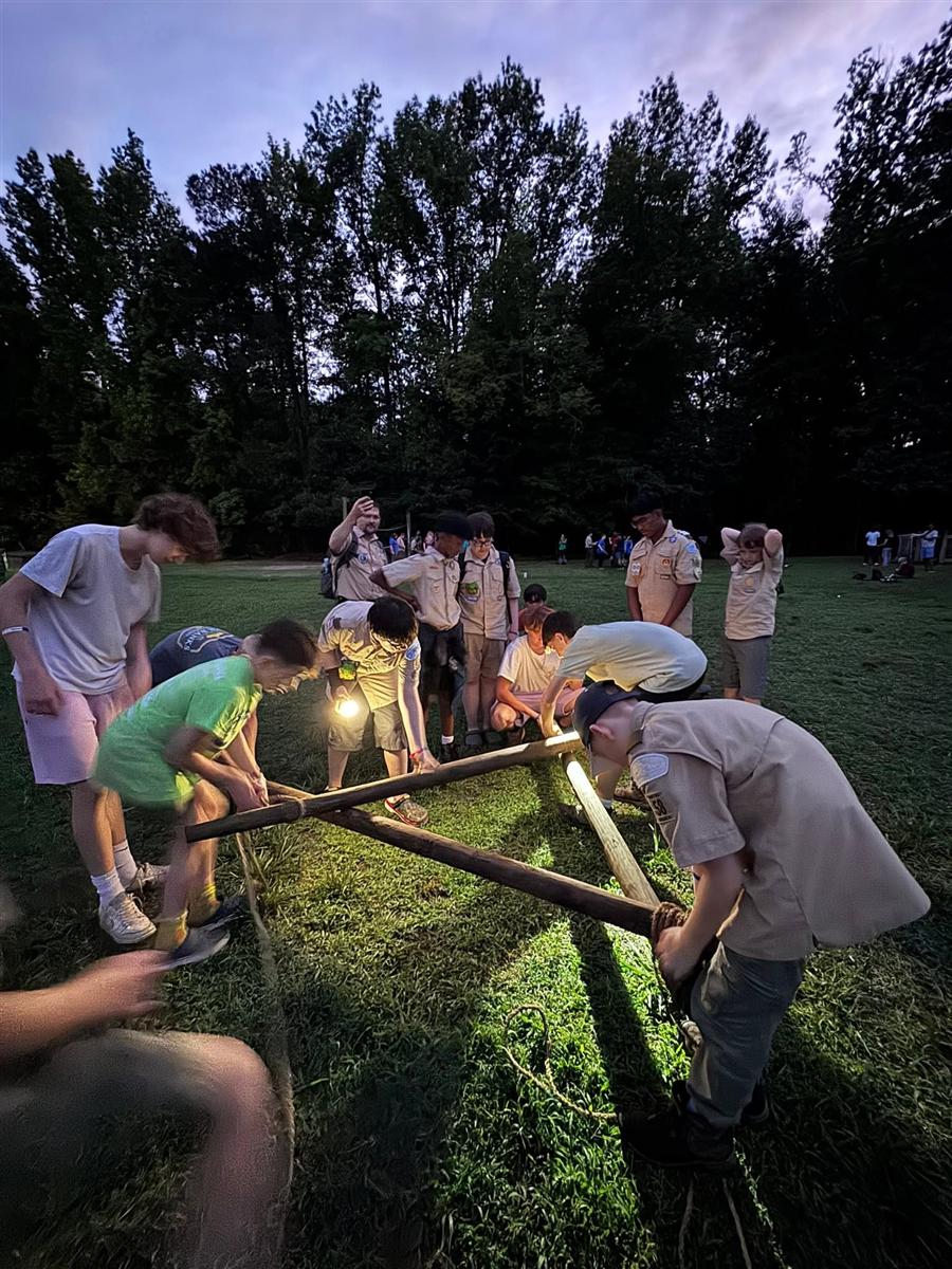 Troop 58 Scouts lashing a pioneering project together after dark